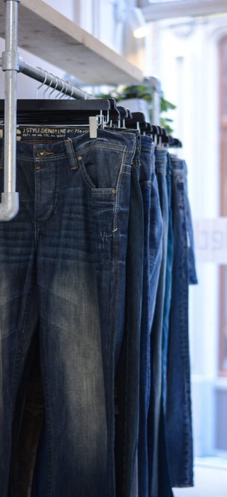 Detail van kwalitatieve tweedehands jeans en denim broeken in de rekken bij Marleen's kledingstudio in Zutphen.